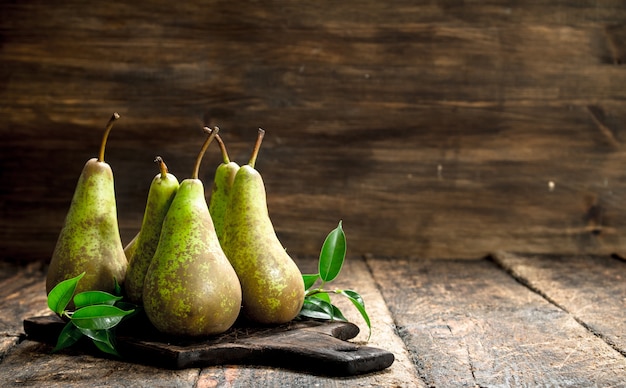 Verse peren met bladeren. Op een houten tafel.