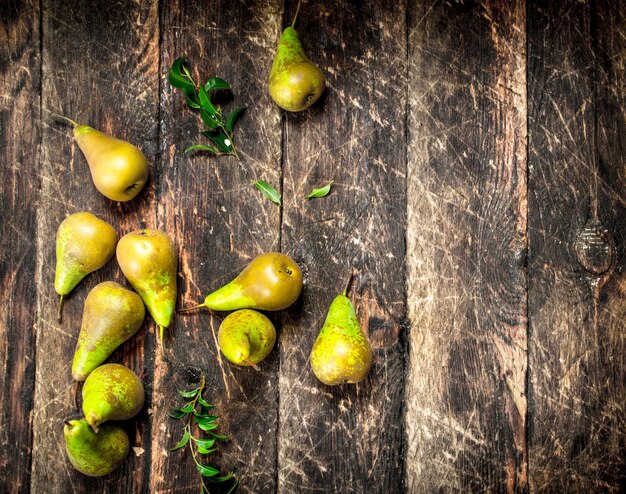 Verse peren met bladeren op houten tafel.