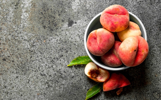 Verse perziken in een kom op een rustieke achtergrond