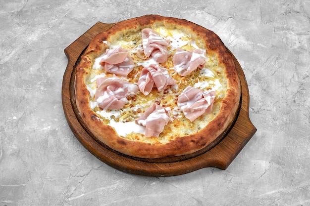 Verse pizza met ham en ananas op stenen tafel in restaurant