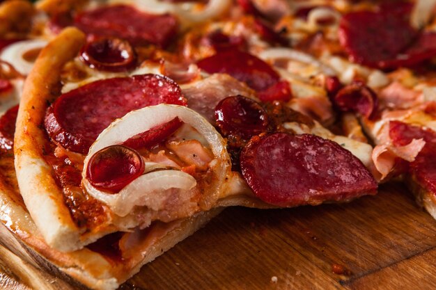 Verse pizza met salami, kille peper, tomaten, ui en kaas close-up weergave. italiaanse keuken.