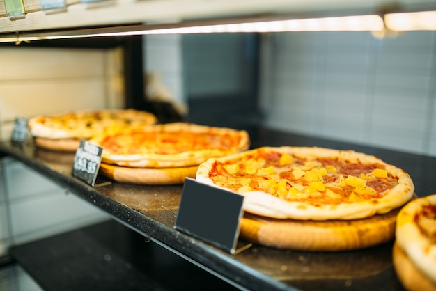 Verse pizza op plank in de close-up van de voedselopslag, niemand. Lege prijs, traditionele Italiaanse keuken in markt