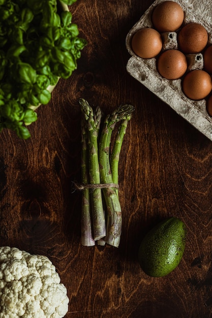 Verse producten fotografie Groenten op de houten tafel Asperges bloemkool eieren avocado basilicum
