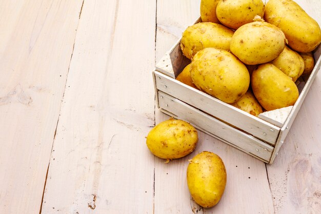 Verse rauwe aardappelen in houten doos