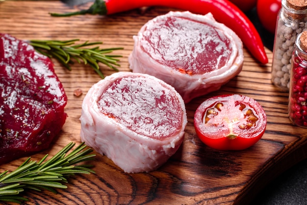 Verse rauwe biefstuk Mignon, met zout, peperkorrels, tijm, tomaten. Rauw gemarmerd vlees Biefstuk en kruiden