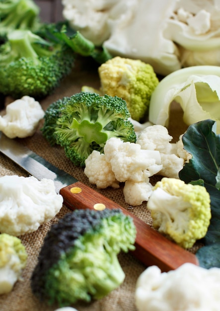 Verse rauwe bloemkool en broccoli op een oude houten tafel