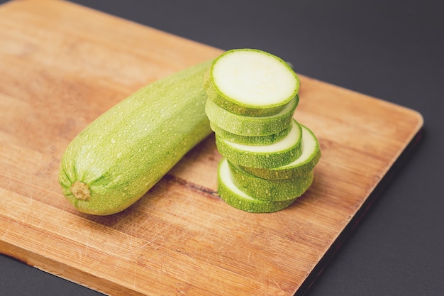 Verse rauwe groene courgette of courgette geheel en in plakjes.