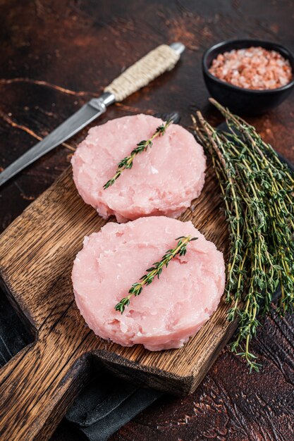 Verse rauwe hamburgers patty kotelet van kip en kalkoenvlees met kruiden. Donkere achtergrond. Bovenaanzicht.