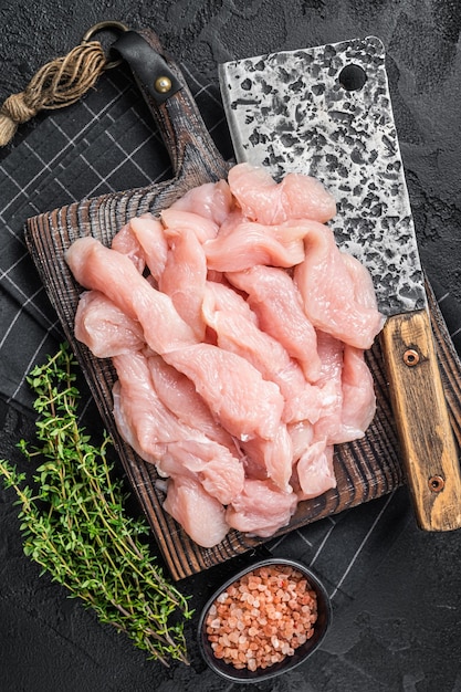 Verse rauwe kalkoenfilet vlees plakjes op een bord van de slager Zwarte achtergrond Bovenaanzicht