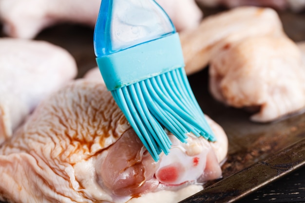 Verse rauwe kippenvleugels op een snijplank op rustieke tafel