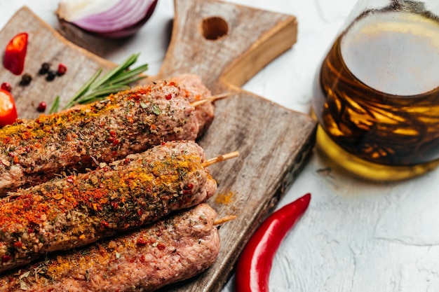 Verse rauwe rundvlees kebab worstjes met kruiden op een lichte achtergrond snijplank. Turkse traditionele vleeskebab. Bovenaanzicht