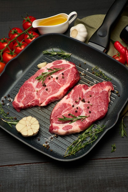 Verse rauwe rundvlees- of varkenssteaks op koekenpan