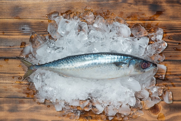 Foto verse rauwe vis op ijs op een houten tafel.