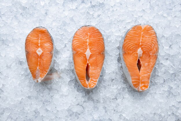 Verse rauwe zalm drie filet op ijs close-up, koude vis uit de oceaan, thuis koken en in restaurant bovenaanzicht