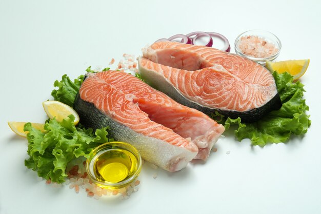 Verse rauwe zalm en ingrediënten voor het koken op witte achtergrond