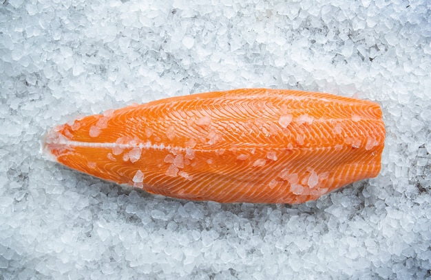 Verse rauwe zalm vis steak op ijs over grijze stenen achtergrond