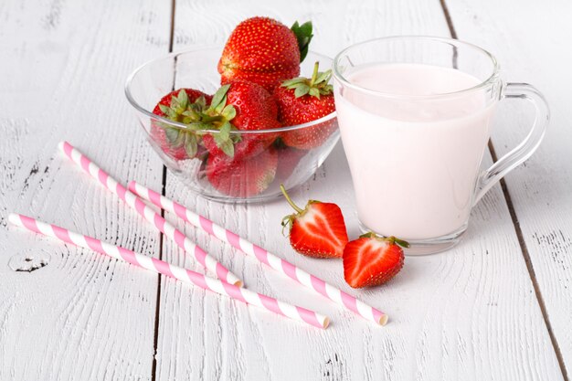 Verse rijpe aardbeien met melk in glas