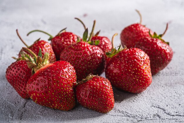 Verse rijpe aardbeivruchten, de bessen van de de zomervitamine op grijze steenlijst, de macro van de hoekmening