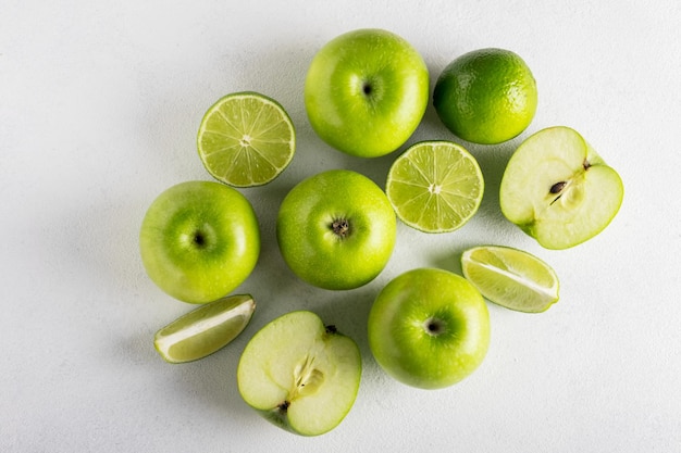 Verse rijpe groene appels en sappige limoenen op een lichte achtergrond