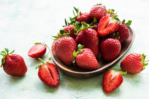 Verse rijpe heerlijke aardbeien in een houten kom op een groene houten achtergrond