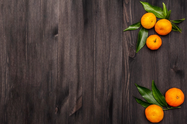 Verse rijpe mandarijnen met bladeren op houten tafel