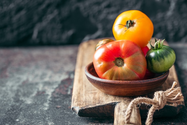 Verse, rijpe multi gekleurde tomaten op een donkere achtergrond.