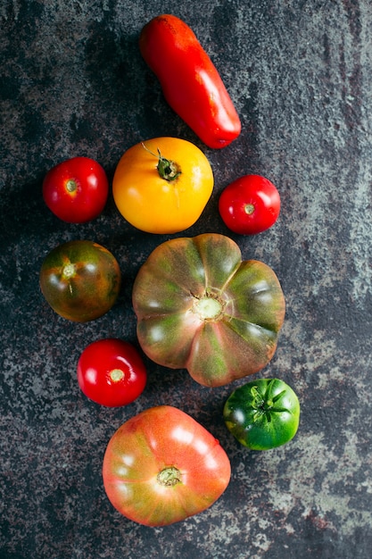 Verse, rijpe multi gekleurde tomaten op een donkere achtergrond.