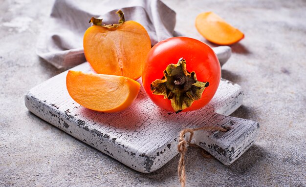 Verse rijpe persimmon op witte snijplank