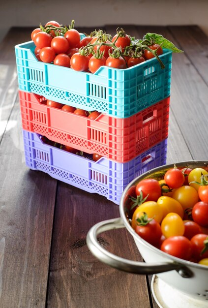 Verse rijpe tomaten zijn in de dozen op broun houten tafel