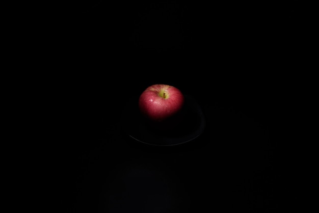 Verse rode appel Op een zwarte achtergrond met waterdruppels vallen de lichten met ruimte voor tekst