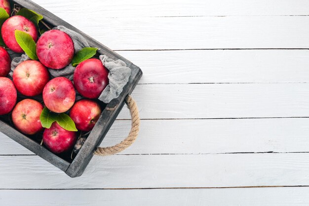 Verse rode appels in een houten kist Biologisch voedsel Op een witte houten achtergrond Bovenaanzicht Vrije ruimte voor tekst