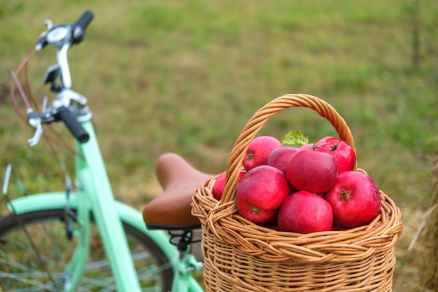 Verse rode appels in een rieten mand op de kofferbak van een vintage fiets