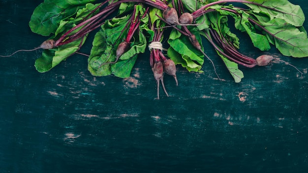 Verse rode biet met groene bladeren Op een houten achtergrond Bovenaanzicht Kopieer de ruimte