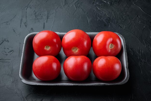 Verse rode biologische tomaten, op zwarte achtergrond