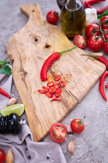 Verse rode chilipepers ronde plakjes op houten snijplank bij binnenlandse keuken