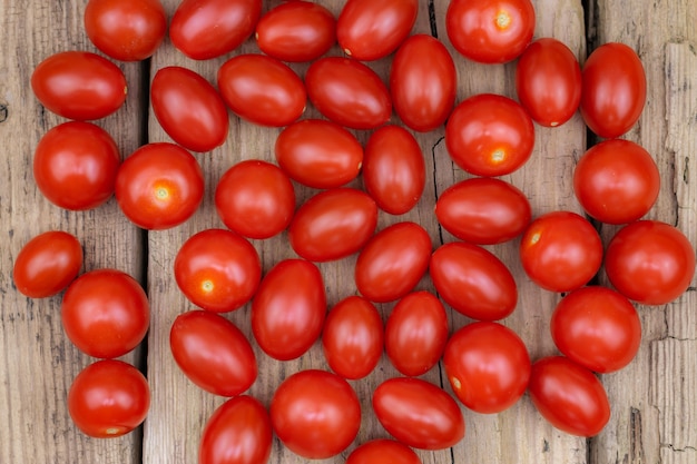 Foto verse rode kleine tomaten op oude houten planken