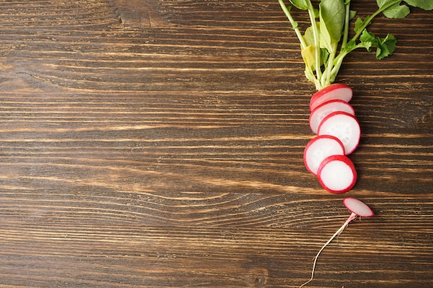 Verse rode radijsplakken op houten ruimte als achtergrond voor platte tekst