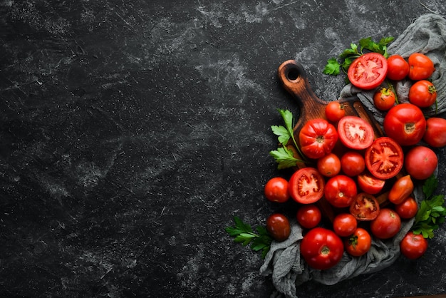 Verse rode tomaten op zwarte stenen achtergrond Groenen Bovenaanzicht Vrije ruimte voor uw tekst