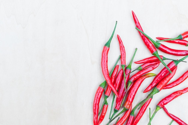 Verse roodgloeiende chilipepers met pittig op de houten tafel met kopie ruimte