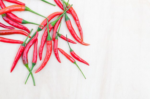 Verse roodgloeiende chilipepers met pittig op de houten tafel met kopie ruimte