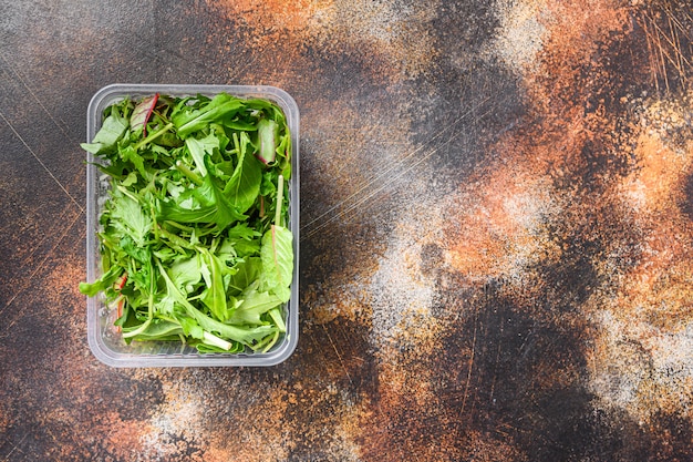 Verse Rucola Snijbiet en Mizuna in ruimte van de plastic container de hoogste mening voor tekst.