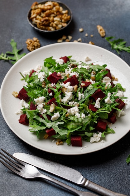 Verse salade met rucola, feta-kaas, walnoot en biet op witte plaat