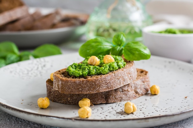 Verse sandwich met pesto en kikkererwten op roggebrood op een bord op tafel Closeup