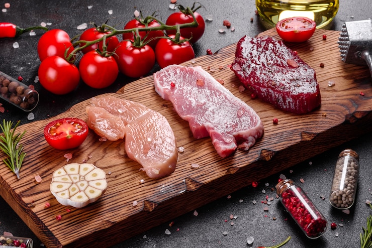 Foto verse, sappige biefstuk van rundvlees, varkensvlees en kip met groenten klaar om te koken. steaks van verschillende soorten vlees bereid om te koken