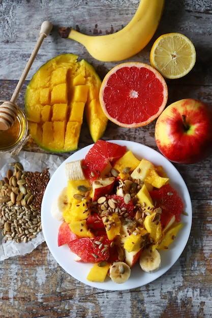 Verse, sappige fruitsalade op een plaat met mango, grapefruit en zaden