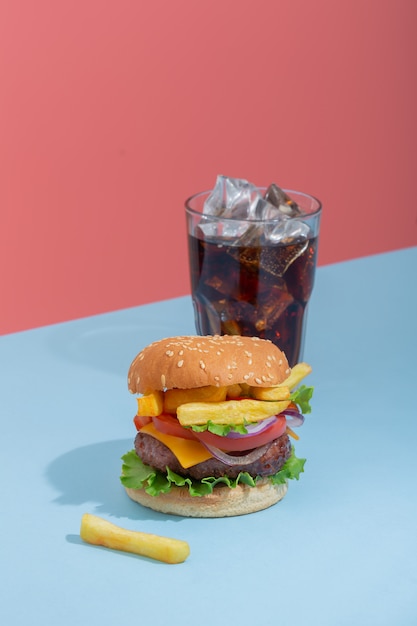 Verse, sappige rundvleeshamburger die op creatieve blauwe achtergrond, isometrische verticale oriëntatie wordt geplaatst