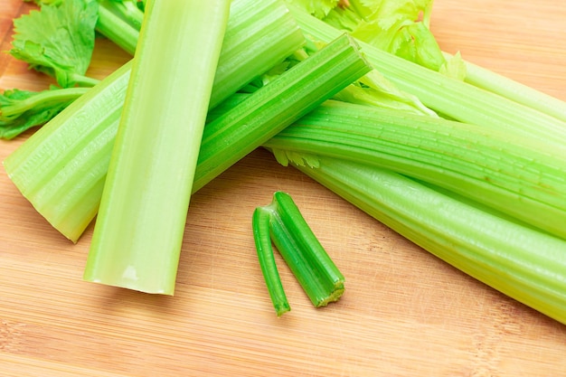 Verse selderijstengel en gehakte bleekselderijstengels op houten snijplank Veganistische en vegetarische cultuur Rauw voedsel Gezonde voeding met negatief caloriegehalte Afslankend voedsel