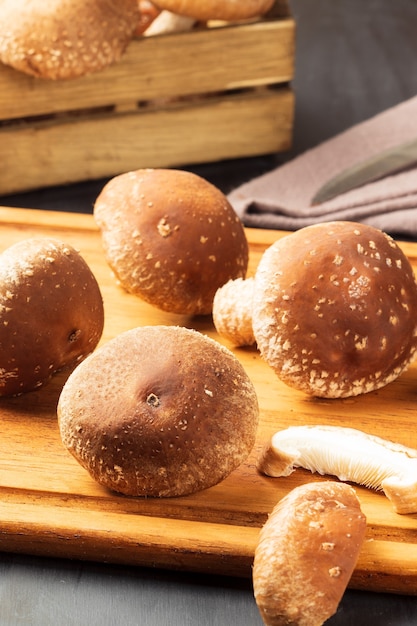 Verse shiitake-paddenstoelen op snijplank.