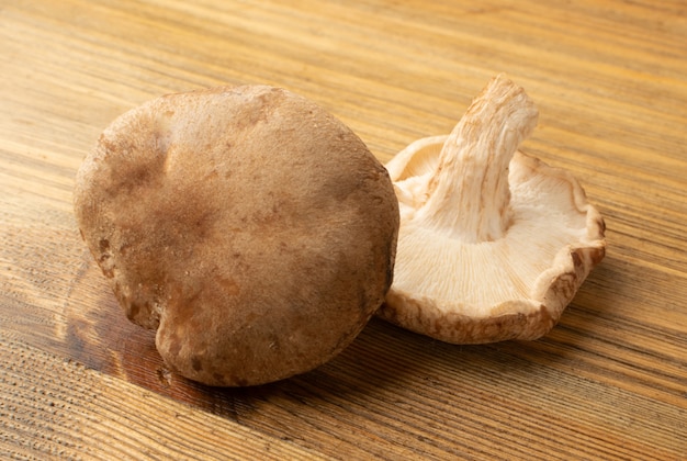 Verse shiitake-paddestoelen op houten achtergrond. Rauwe shitake, gezonde biologische Aziatische schimmels close-up