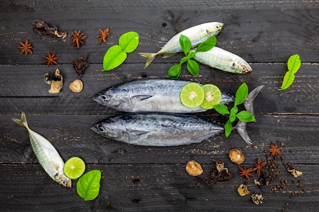 Verse skipjack tonijnvissen op donkere zwarte houten. vis met kruiden en groenten